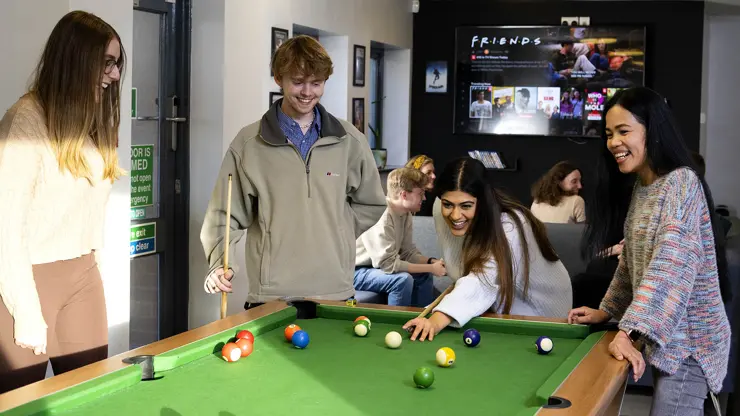 Students playing pool in Roeburn common room