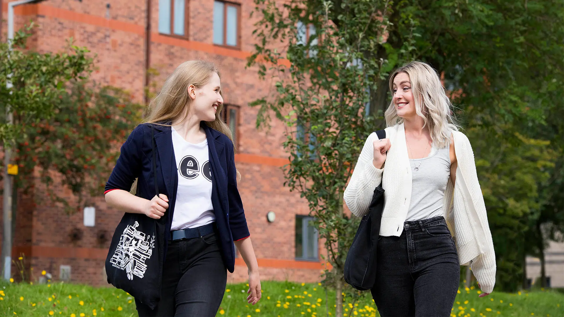 Students enjoying campus in summer. Walking, talking in groups, in front of halls and EIC building