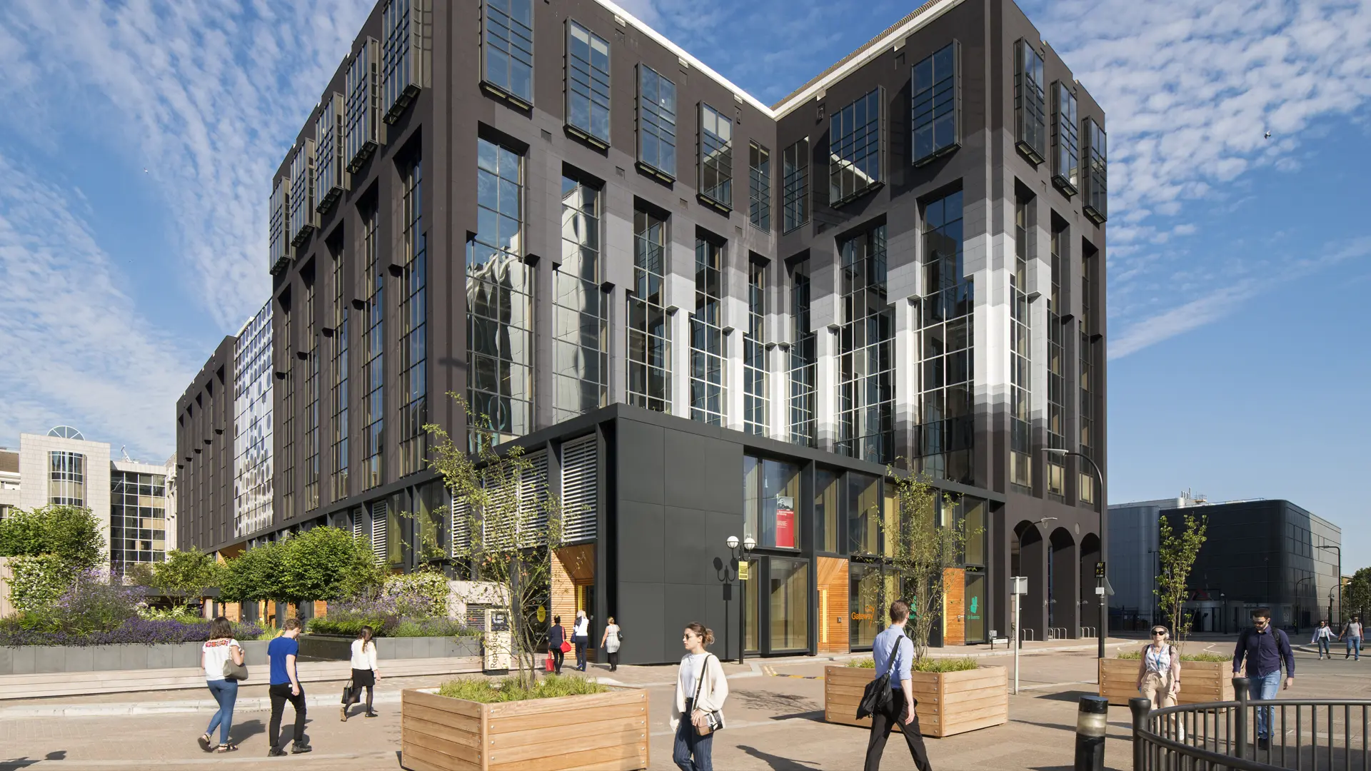 glass building in london with people walking outside the building