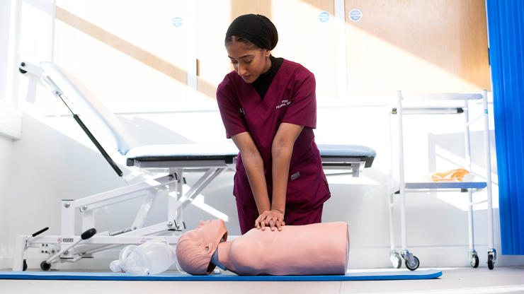 Student delivering CPR on mannequin 