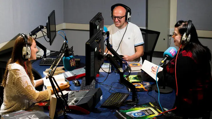 Three students using our audio book recording facilities