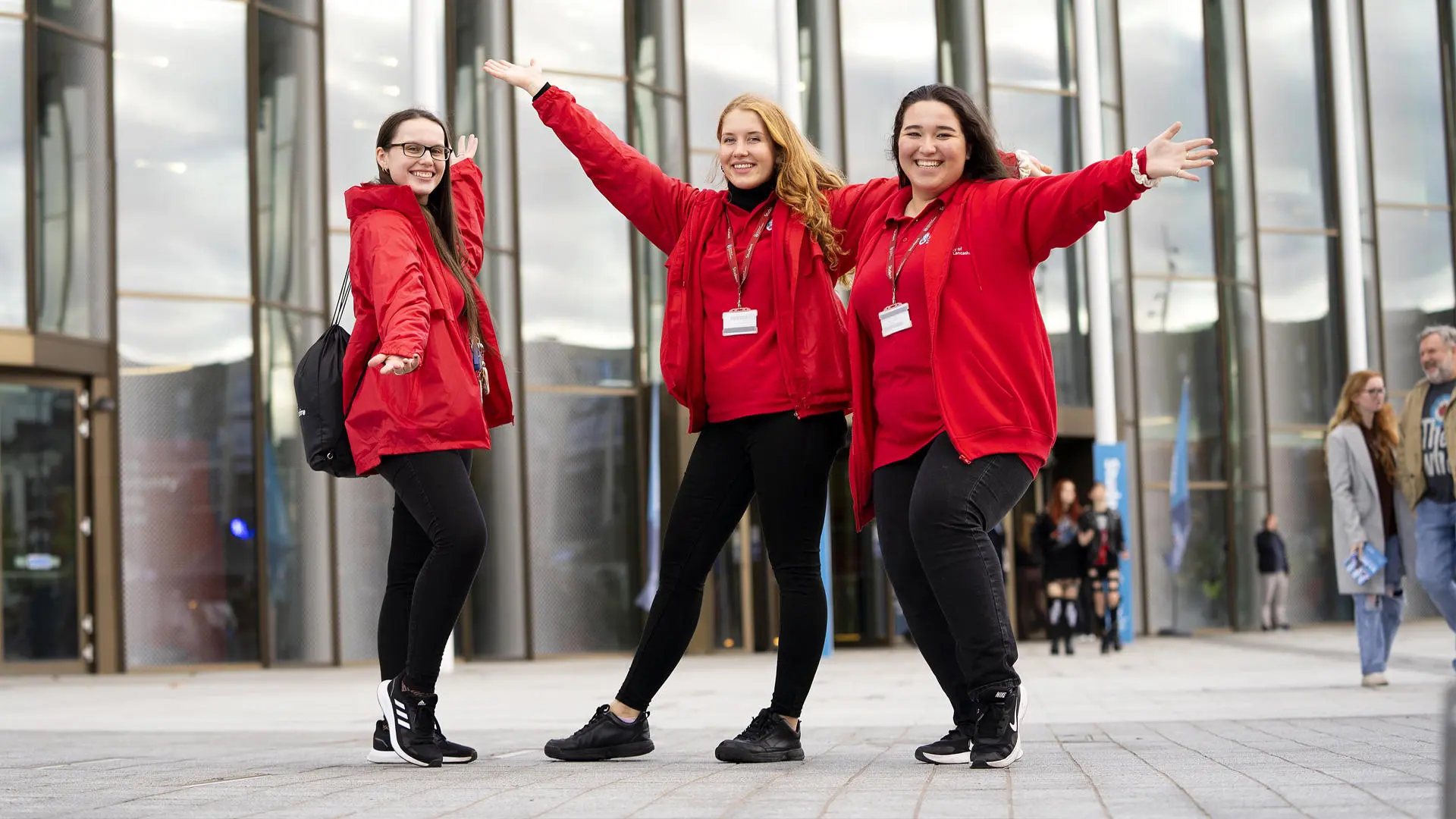 group of three student ambassadors wearing red stood outside the student centre at an open day