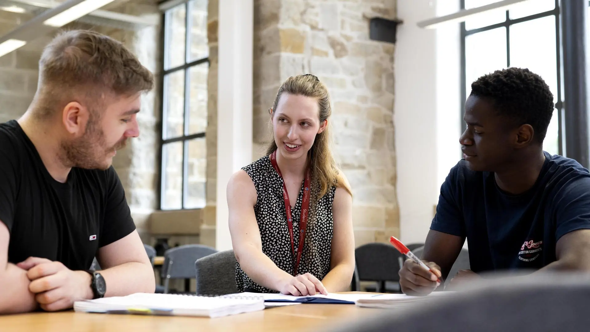 student smiling in classroom chatting to tutor