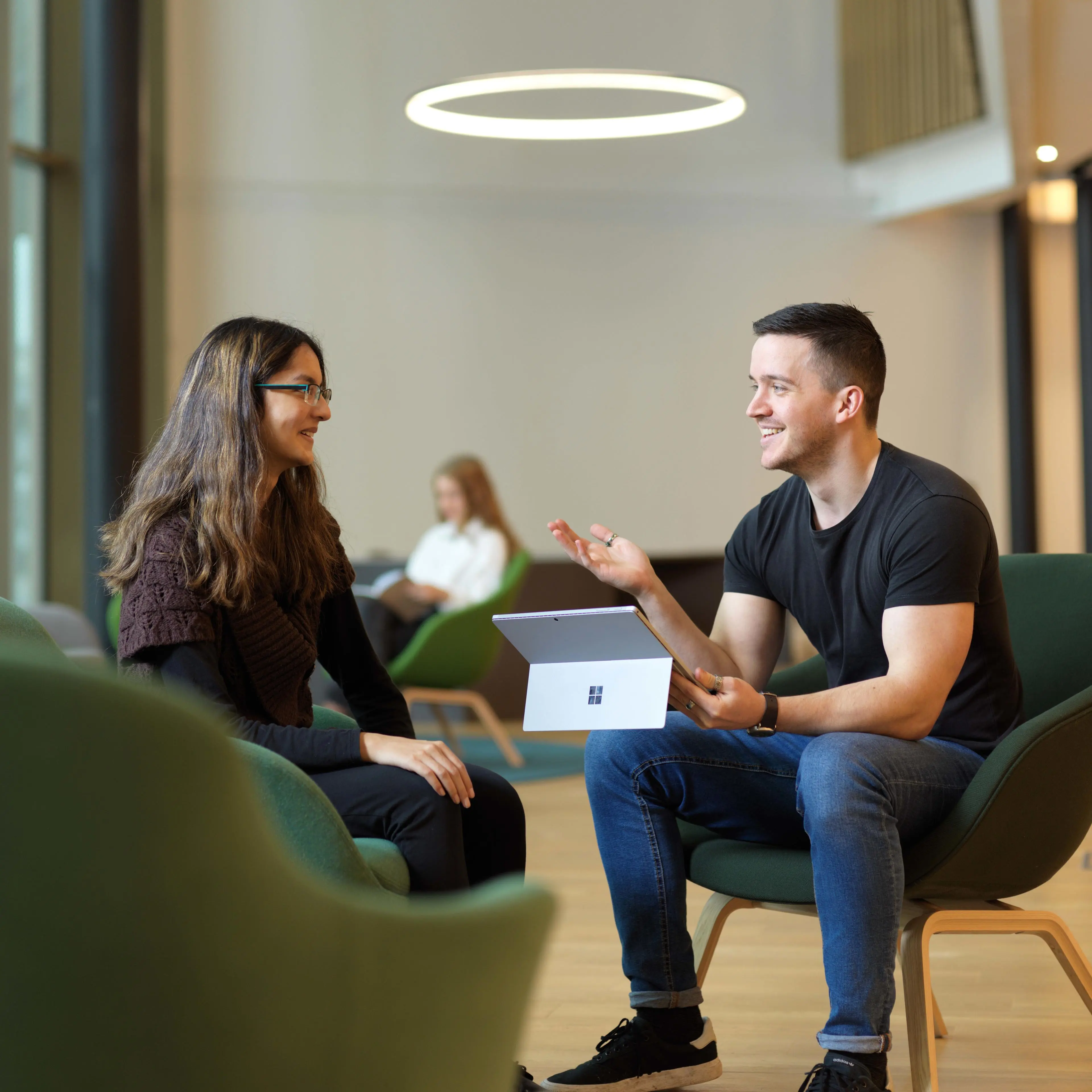 Member of staff talking to a student about support in the Student Centre