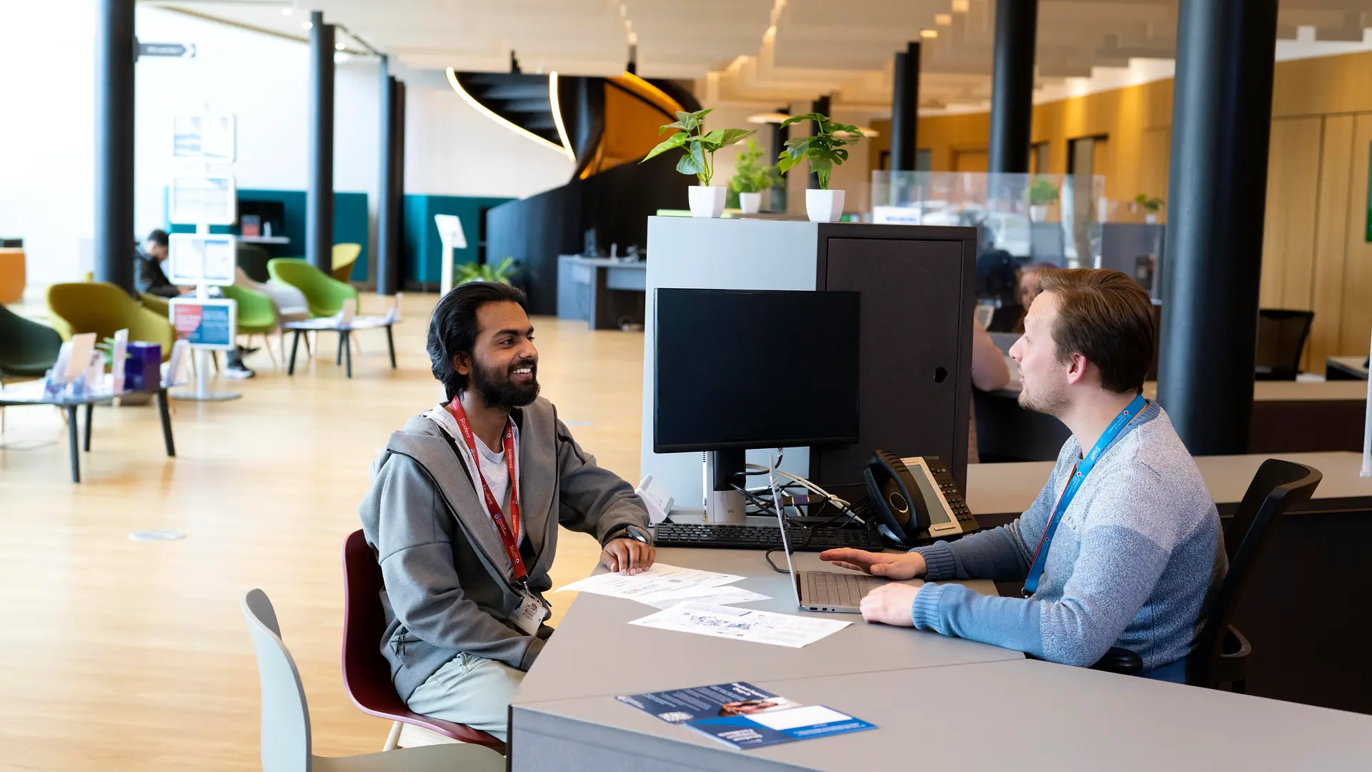 Student sitting with member of staff in the Student Centre at a desk