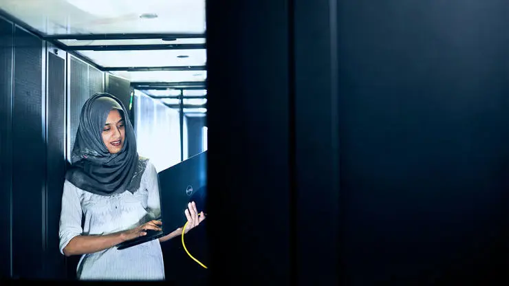 A computing student completing work on a laptop