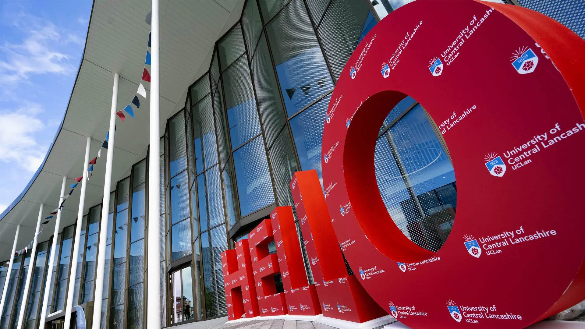 big red letters spelling out hello with the uclan logo on it in front of the student centre